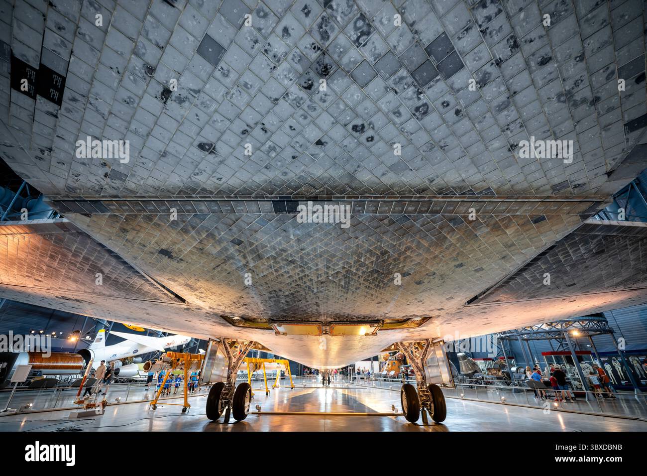 CHANTILLY, Virginie — des tuiles de bouclier thermique, brûlées par la rentrée atmosphérique, sont visibles sous la navette spatiale Discovery comme exposé dans le hangar spatial James S. McDonnell au Steven F. Udvar-Hazy Center du Smithsonian National Air and Space Museum. Discovery a effectué 39 missions de 1984 à 2011, plus que tout autre engin spatial de l'histoire, accumulant 365 jours dans l'espace et parcourant 149 millions de miles (240 millions de kilomètres). L'orbiteur a servi de véhicule de retour au vol de la NASA après la catastrophe de Challenger en 1986 et celle de Columbia en 2003. Découverte déployée Banque D'Images