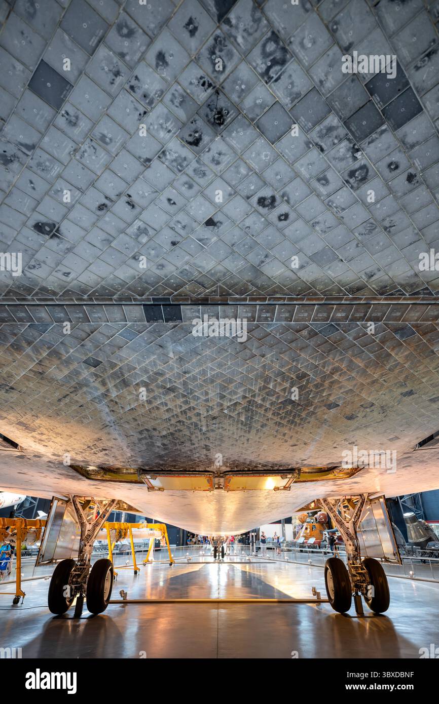 CHANTILLY, Virginie — des tuiles de bouclier thermique, brûlées par la rentrée atmosphérique, sont visibles sous la navette spatiale Discovery comme exposé dans le hangar spatial James S. McDonnell au Steven F. Udvar-Hazy Center du Smithsonian National Air and Space Museum. Discovery a effectué 39 missions de 1984 à 2011, plus que tout autre engin spatial de l'histoire, accumulant 365 jours dans l'espace et parcourant 149 millions de miles (240 millions de kilomètres). L'orbiteur a servi de véhicule de retour au vol de la NASA après la catastrophe de Challenger en 1986 et celle de Columbia en 2003. Découverte déployée Banque D'Images