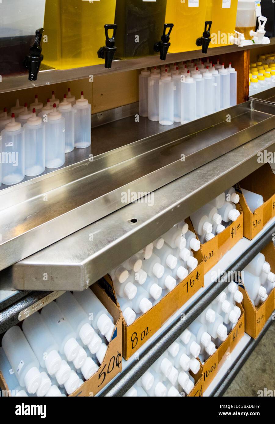Centre alimentaire en vrac, rangées de bouteilles en plastique rechargeables et distributeurs de liquide. Banque D'Images