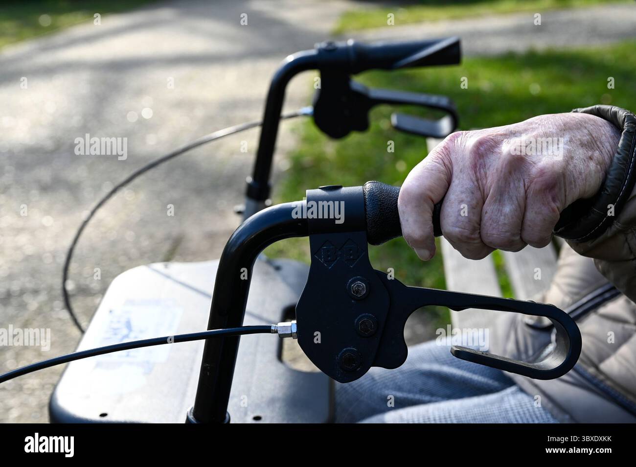 ALLEMAGNE, Hambourg, Corona virus, COVID-19 , maison fermée pour personnes âgées, vieille femme assise seule / DEUTSCHLAND, Hambourg, geschlossenes Pflegeheim, kein Zutritt für Besucher, Alte Frau sitzt alleine auf Parkbank vor dem Heim Banque D'Images