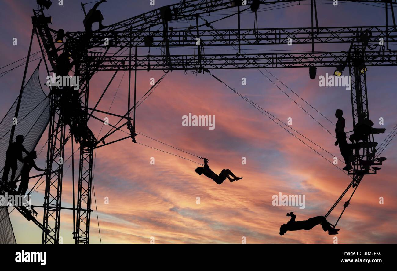 Sibiu City, Roumanie - 28 juin 2022 silhouettes d'artistes de trapèze acrobates de CirkVOST, sur l'échafaudage métallique au Théâtre International Festiv Banque D'Images