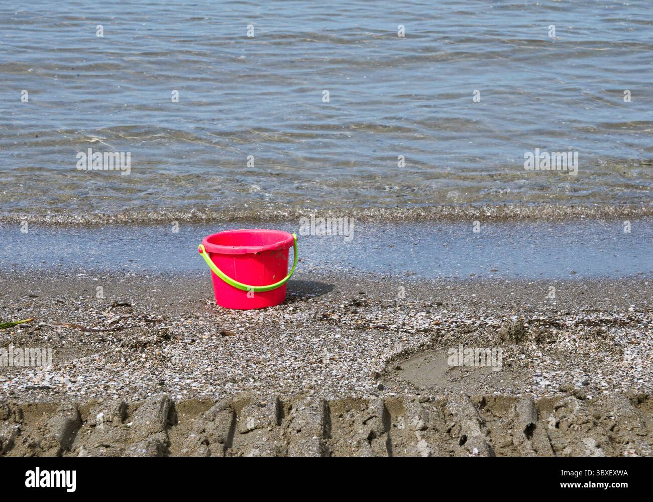 seau en plastique rouge sur le rivage Banque D'Images