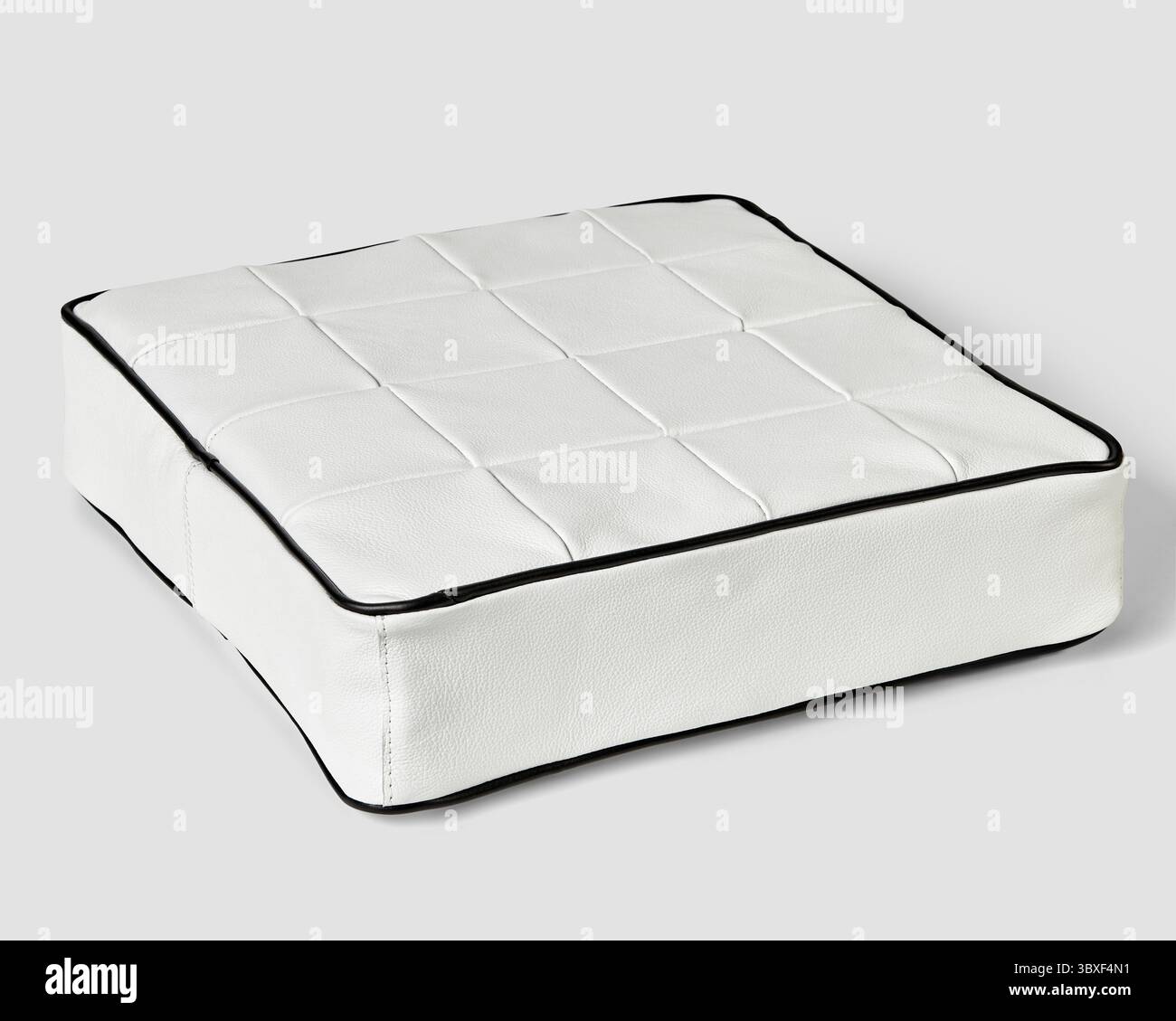 Confortable et élégant, le coussin de sol carré en cuir blanc ajoute une touche d'élégance à n'importe quelle pièce Banque D'Images