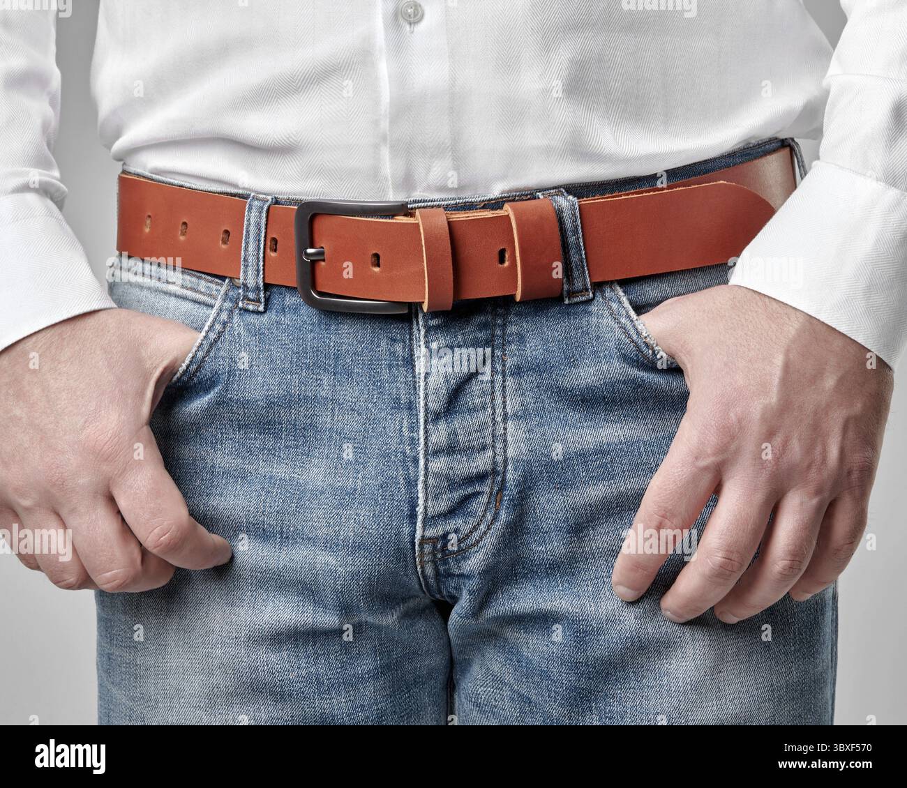 Look masculin décontracté complété par une ceinture en cuir véritable marron faite à la main avec une personnalisation DE PAPA en relief, alliant style personnel et qualité artisanale Banque D'Images