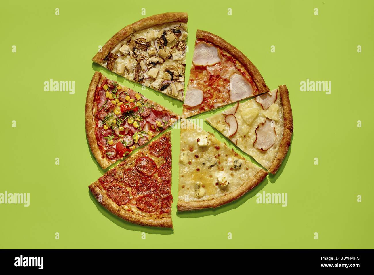 Variété de tranches de pizza avec différentes garnitures créant une pizza complète sur un fond vert vibrant Banque D'Images