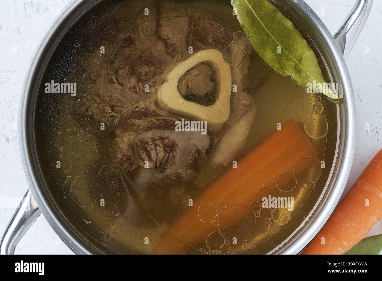 Bouillon de viande de bœuf, ossobuco sur os, soupe riche dans une casserole, longue cuisson lente et languissante. Bouillon sain et nutritif, bon pour la digestion. Macro, Fermer u Banque D'Images Bouillon de viande de bœuf, ossobuco sur os, soupe riche dans une casserole, longue cuisson lente et languissante. Bouillon sain et nutritif, bon pour la digestion. Macro, Fermer u Banque D'Images