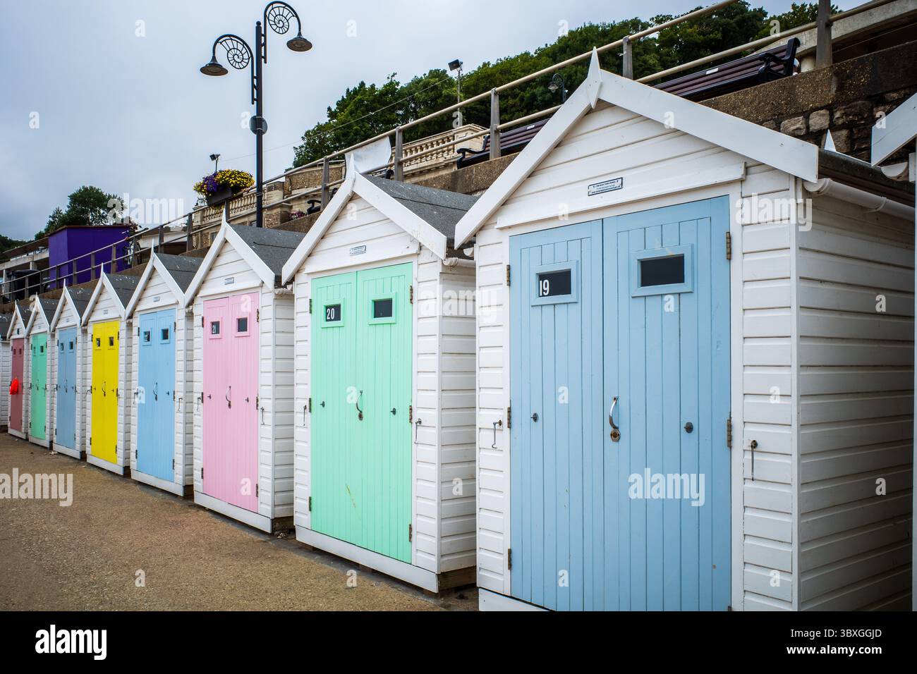Cabanes colorées de plage côtière à Lyme Regis, Dorset en été : une escapade balnéaire animée Banque D'Images