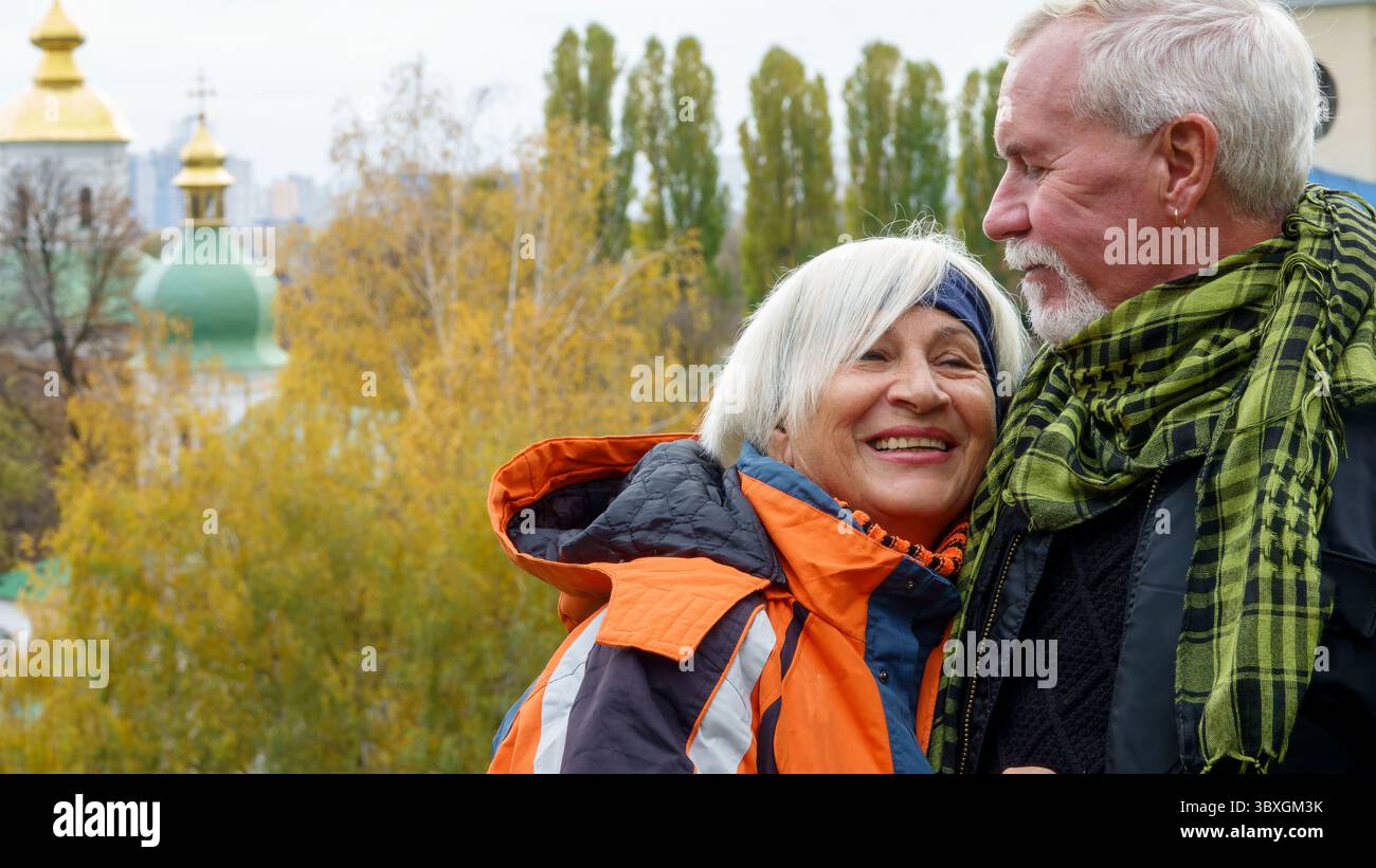 Un vieux couple optimiste aux cheveux gris dans l'amour homme et femme sur fond de plantes d'automne jaunes et d'églises chrétiennes orthodoxes Banque D'Images