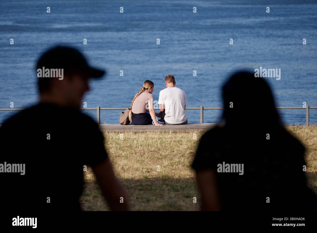 Mayence, Allemagne de l'Ouest. 18 juillet 2025. Un couple par le Rhein regarde un autre couple par le Rhein. Banque D'Images