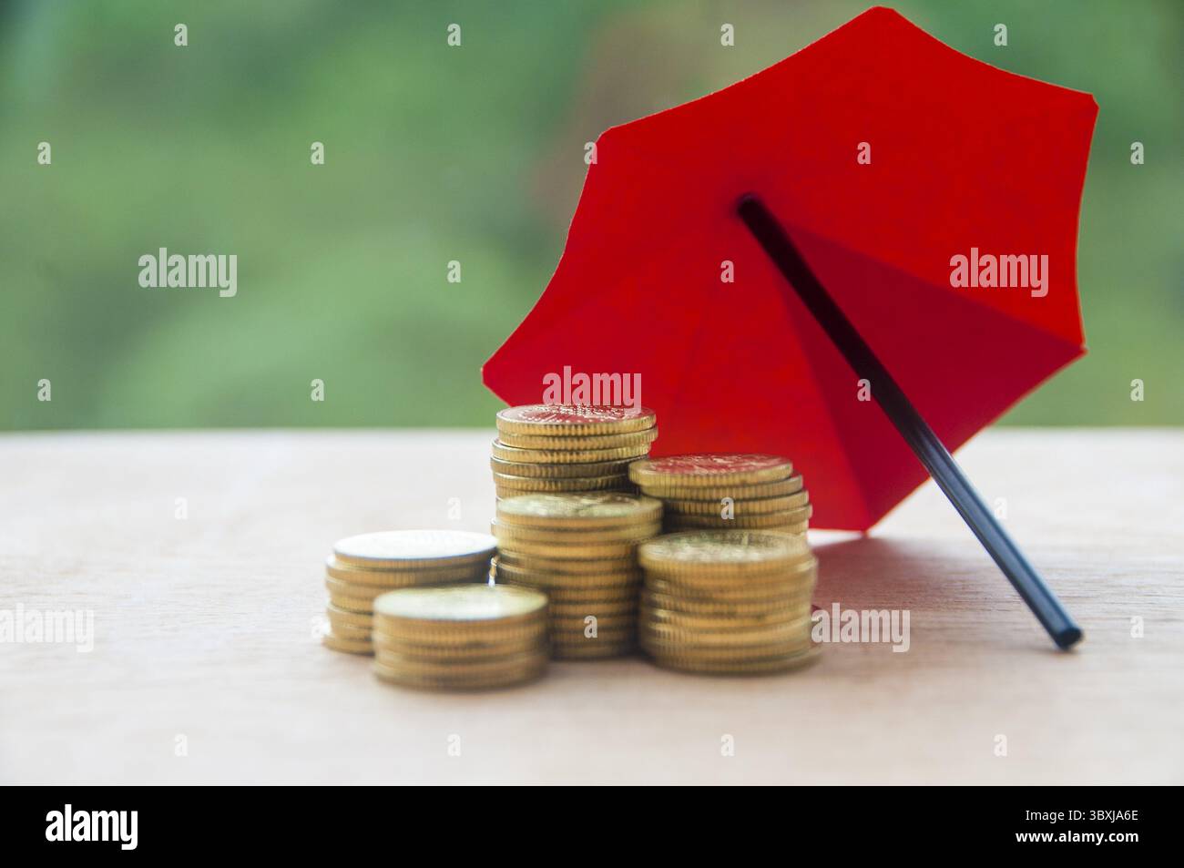 Parapluie recouvrant les pièces d'or représentant la protection et la sécurité. Concept de sécurité et d'assurance Banque D'Images