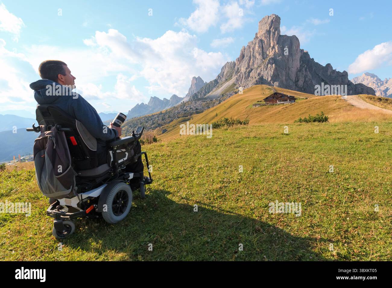 Homme handicapé en fauteuil roulant explore le paysage magnifique du col de Giau dans les Dolomites en Italie. Montagnes majestueuses et beauté naturelle dans un Banque D'Images