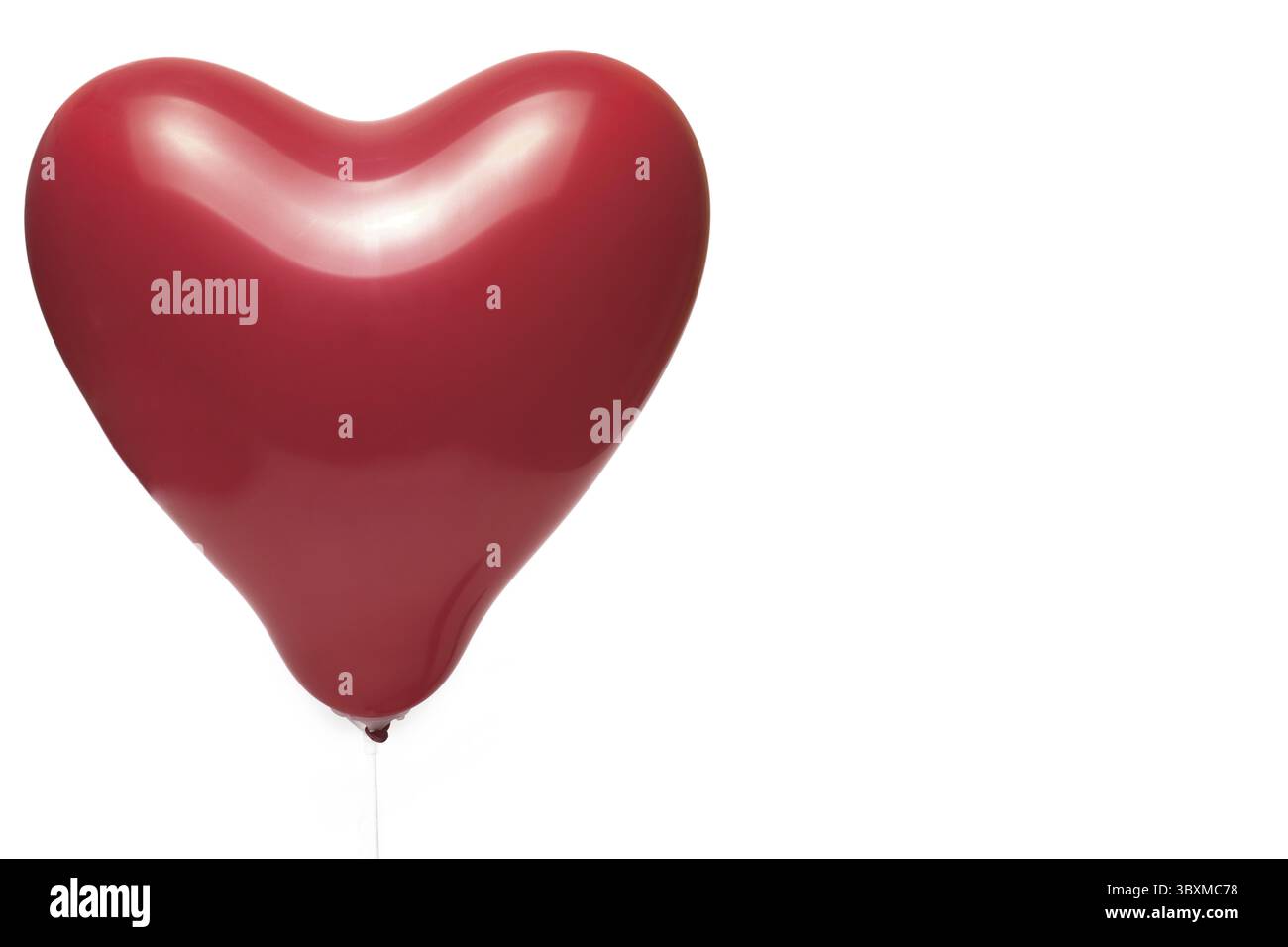 Gros plan d'un ballon rouge rempli d'air en forme de coeur sur fond blanc concept pour l'anniversaire de la relation d'amour Banque D'Images