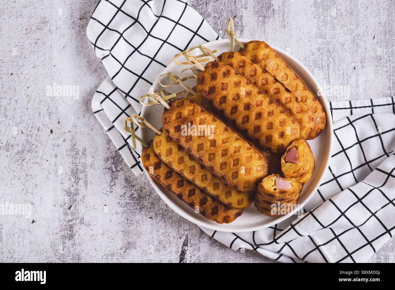 Nourriture, gros plan d'une pile de chiens de maïs maison avec saucisse sur une assiette sur une vue de dessus de table Banque D'Images
