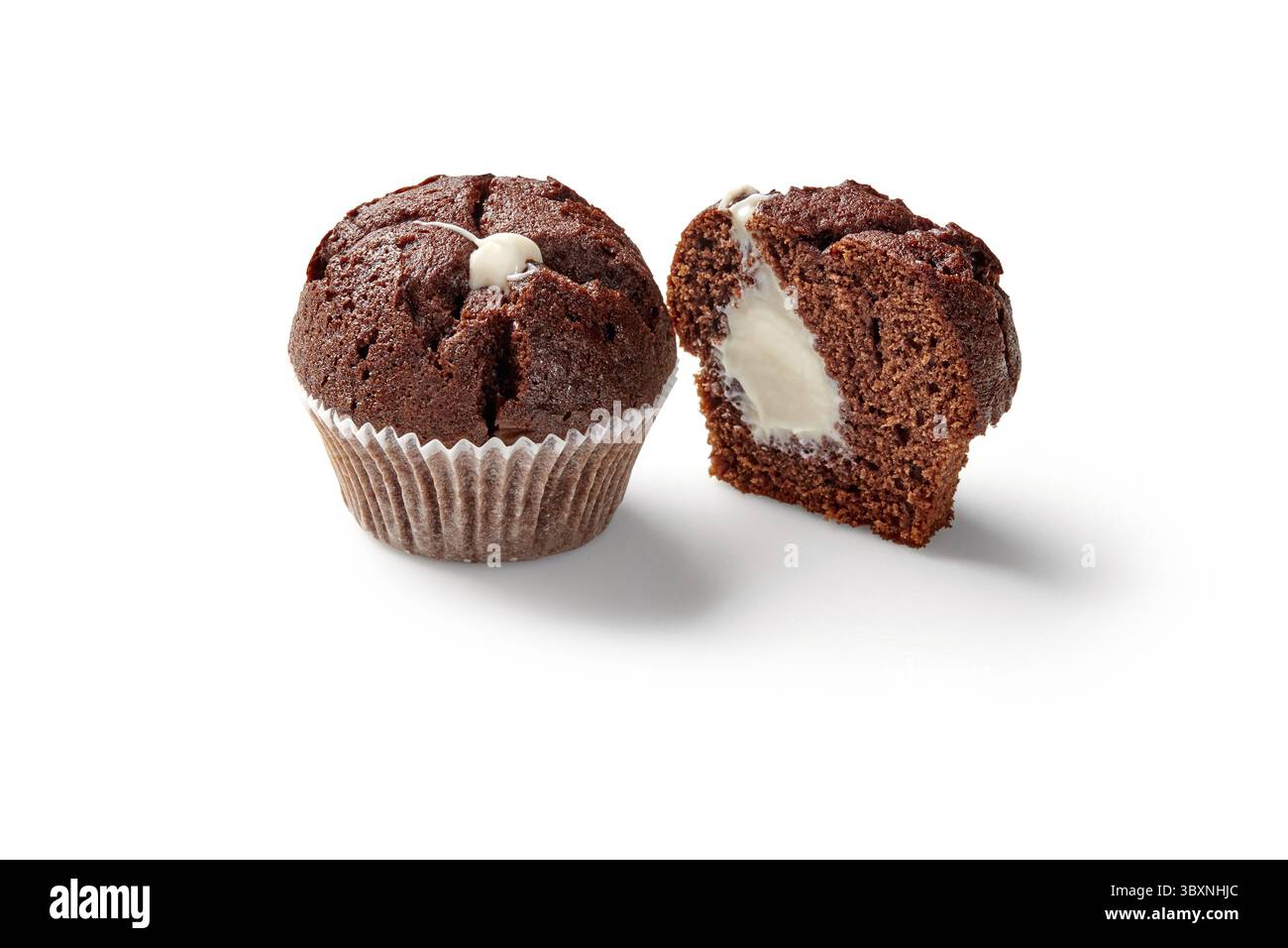Délicieux muffins aérés entiers et tranchés au chocolat doux dans des gobelets en papier cuisson avec une garniture crémeuse délicate, isolés sur fond blanc Banque D'Images
