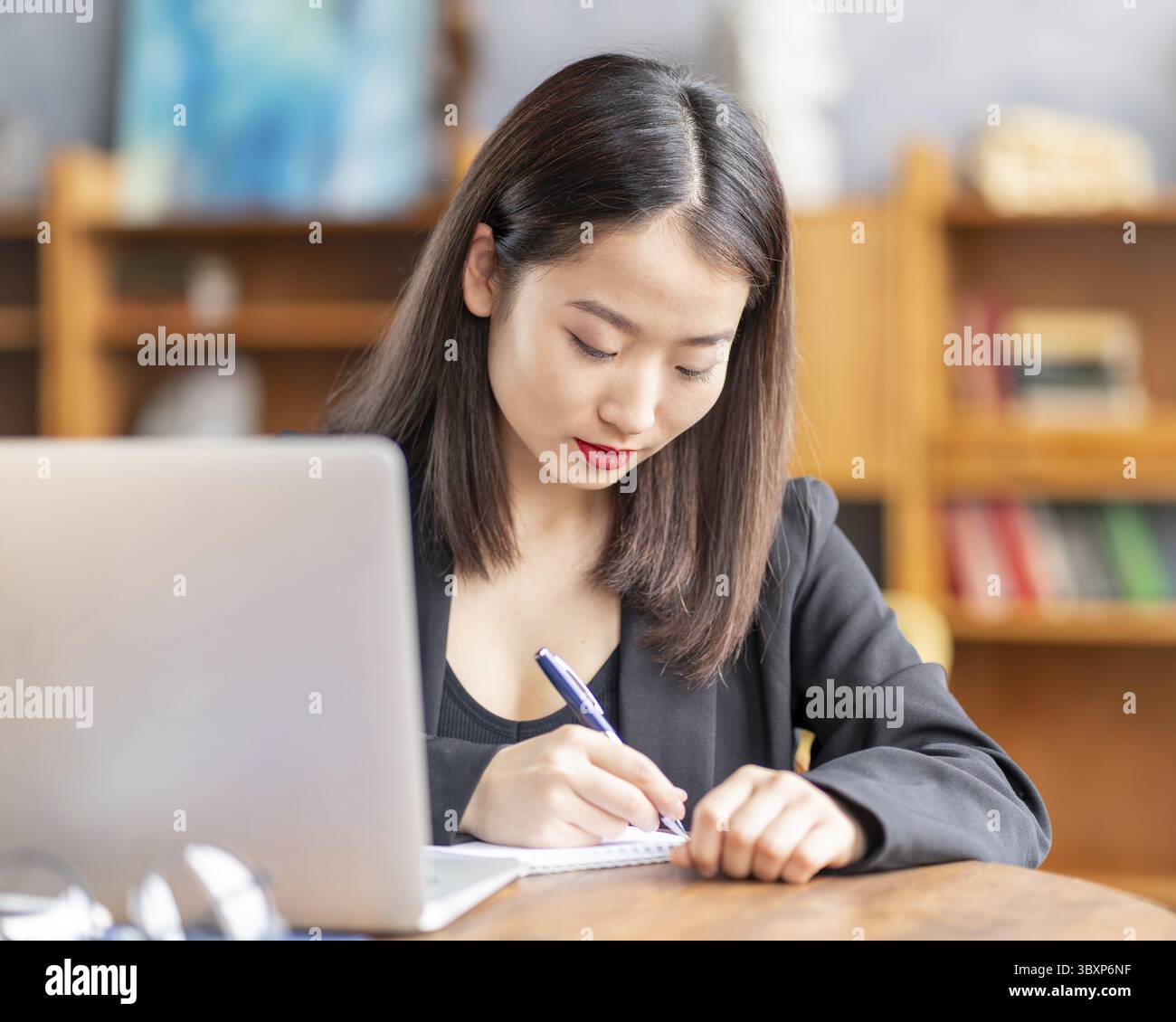 Femme asiatique étudiant cours en ligne, enseignement à distance sur ordinateur portable. Femme d'affaires japonaise travaillant. Travail indépendant écrit dans le bloc-notes Banque D'Images
