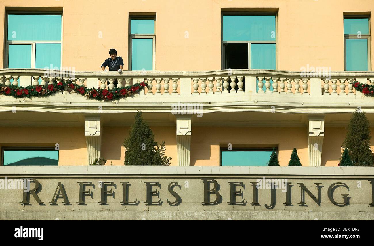 19 novembre 2008, PÉKIN, CHINE : un employé de l'hôtel accroche des décorations de Noël sur la façade de l'hôtel cinq étoiles de Raffles dans le centre de Pékin le 19 novembre 2008. Le secteur de la restauration et de l'hôtellerie en Chine a été le plus touché par la crise financière, 42 % des entreprises du secteur estimant que les affaires au quatrième trimestre vont chuter, contre seulement 10 % s'attendent à une augmentation, selon une enquête menée par le Département du recensement et des statistiques. (Crédit image : © Stephen Shaver/ZUMA Press Wire) Banque D'Images