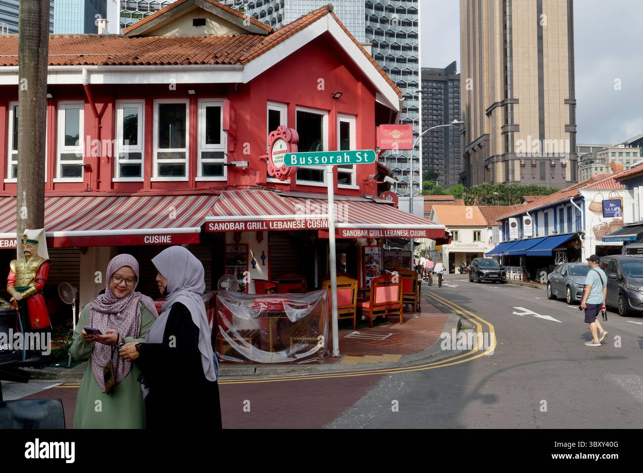 Bussorah Street à Kampong Glam, un quartier charmant et coloré dominé par les Malais à Singapour ; avec deux femmes malaises portant un foulard au premier plan Banque D'Images