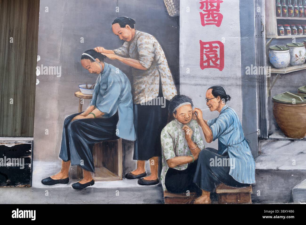 Une murale dans Chinatown, Singapour, représentant (l) une femme ramassant des poux sur les cheveux d'une autre femme et une autre femme (R) nettoyant la peau du visage d'une femme Banque D'Images