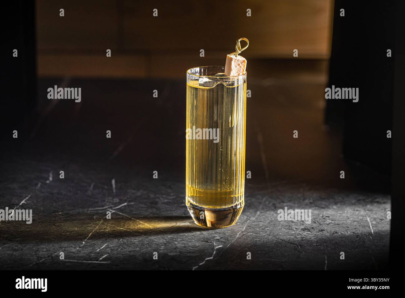 Cocktail highball avec glaçon et lueur dorée Banque D'Images