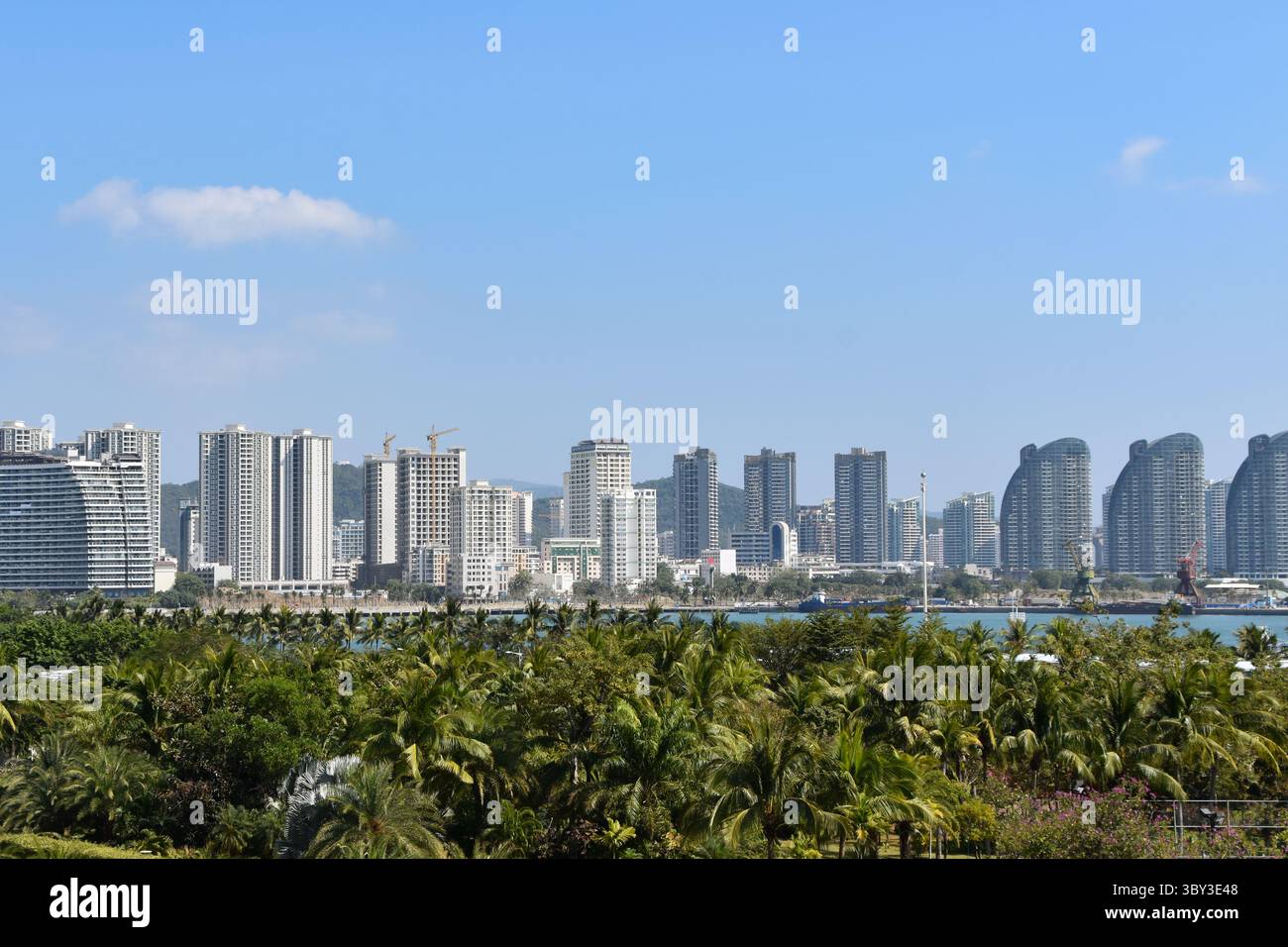 Vue sur la ville de Sanya au-dessus des arbres sur l'île de Hainan Banque D'Images