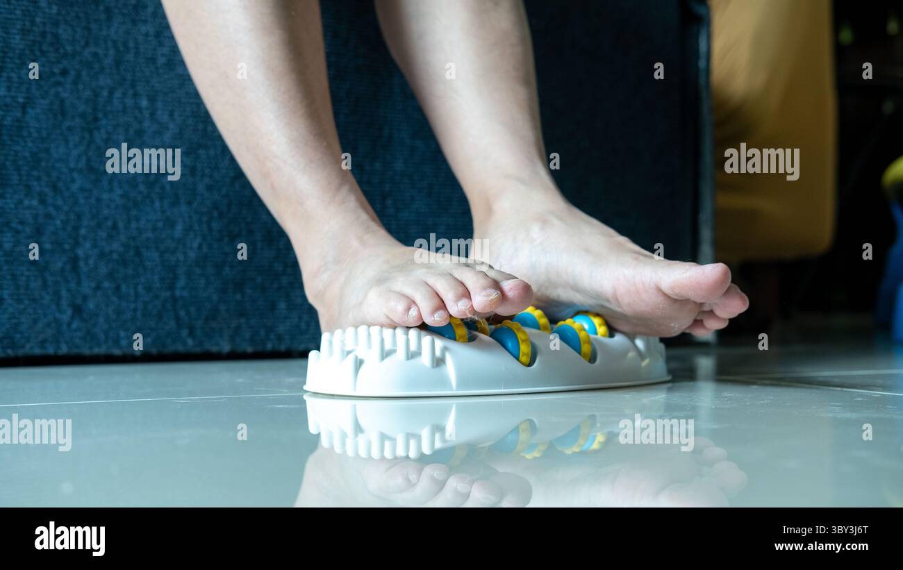 Les jambes d’une femme dans un masseur de pieds, montrant la lutte contre la douleur au pied et le désir de confort. Banque D'Images