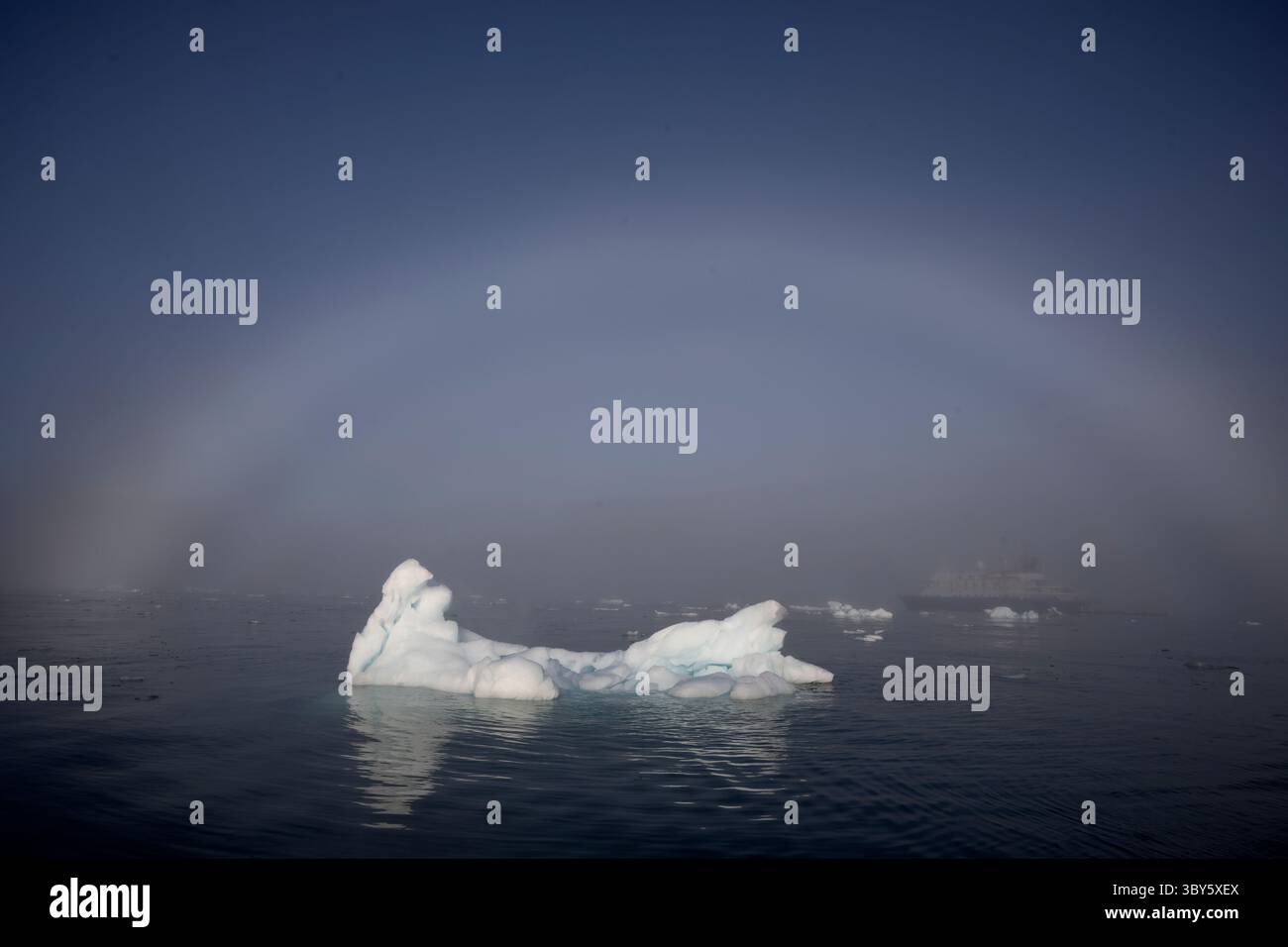 Un arc de brouillard s'étend sur un iceberg dans le Vikingebugt, dans l'Arctique du Groenland, en Europe Banque D'Images