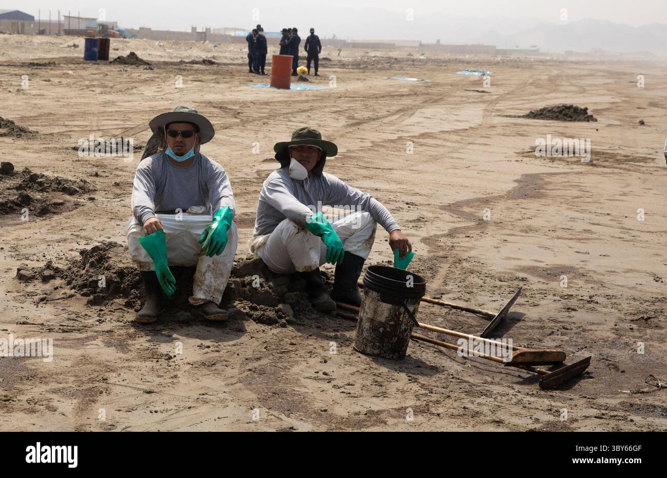 19 janvier 2022, Callao, Pérou : les travailleurs nettoient après un déversement de pétrole, sur la plage de Cavero dans le district de Ventanilla à Callao. Environ 6 000 barils (159 litres chacun) de pétrole se sont déversés lors du déchargement d'un pétrolier à la raffinerie de la Pampilla appartenant à la compagnie énergétique espagnole Repsol. (Crédit image : © Mariana Bazo/ZUMA Press Wire) Banque D'Images