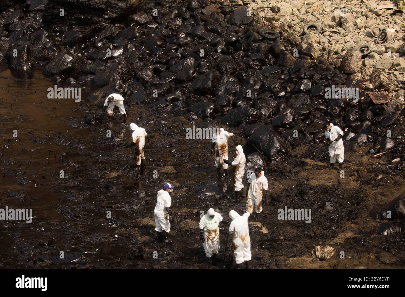 19 janvier 2022, Callao, Pérou : les travailleurs nettoient après un déversement de pétrole, sur la plage de Cavero dans le district de Ventanilla à Callao. Environ 6 000 barils (159 litres chacun) de pétrole se sont déversés lors du déchargement d'un pétrolier à la raffinerie de la Pampilla appartenant à la compagnie énergétique espagnole Repsol. (Crédit image : © Mariana Bazo/ZUMA Press Wire) Banque D'Images