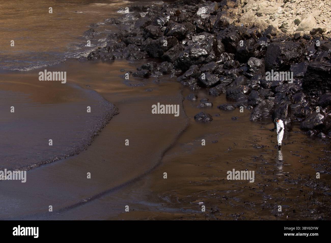 19 janvier 2022, Callao, Pérou : les travailleurs nettoient après un déversement de pétrole, sur la plage de Cavero dans le district de Ventanilla à Callao. Environ 6 000 barils (159 litres chacun) de pétrole se sont déversés lors du déchargement d'un pétrolier à la raffinerie de la Pampilla appartenant à la compagnie énergétique espagnole Repsol. (Crédit image : © Mariana Bazo/ZUMA Press Wire) Banque D'Images