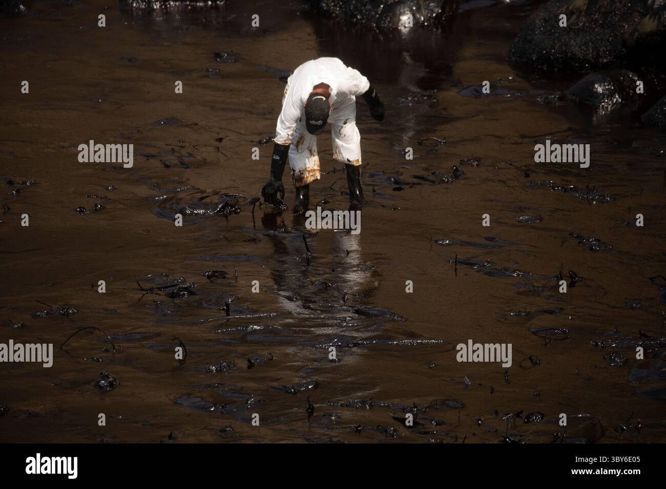 19 janvier 2022, Callao, Pérou : les travailleurs nettoient après un déversement de pétrole, sur la plage de Cavero dans le district de Ventanilla à Callao. Environ 6 000 barils (159 litres chacun) de pétrole se sont déversés lors du déchargement d'un pétrolier à la raffinerie de la Pampilla appartenant à la compagnie énergétique espagnole Repsol. (Crédit image : © Mariana Bazo/ZUMA Press Wire) Banque D'Images