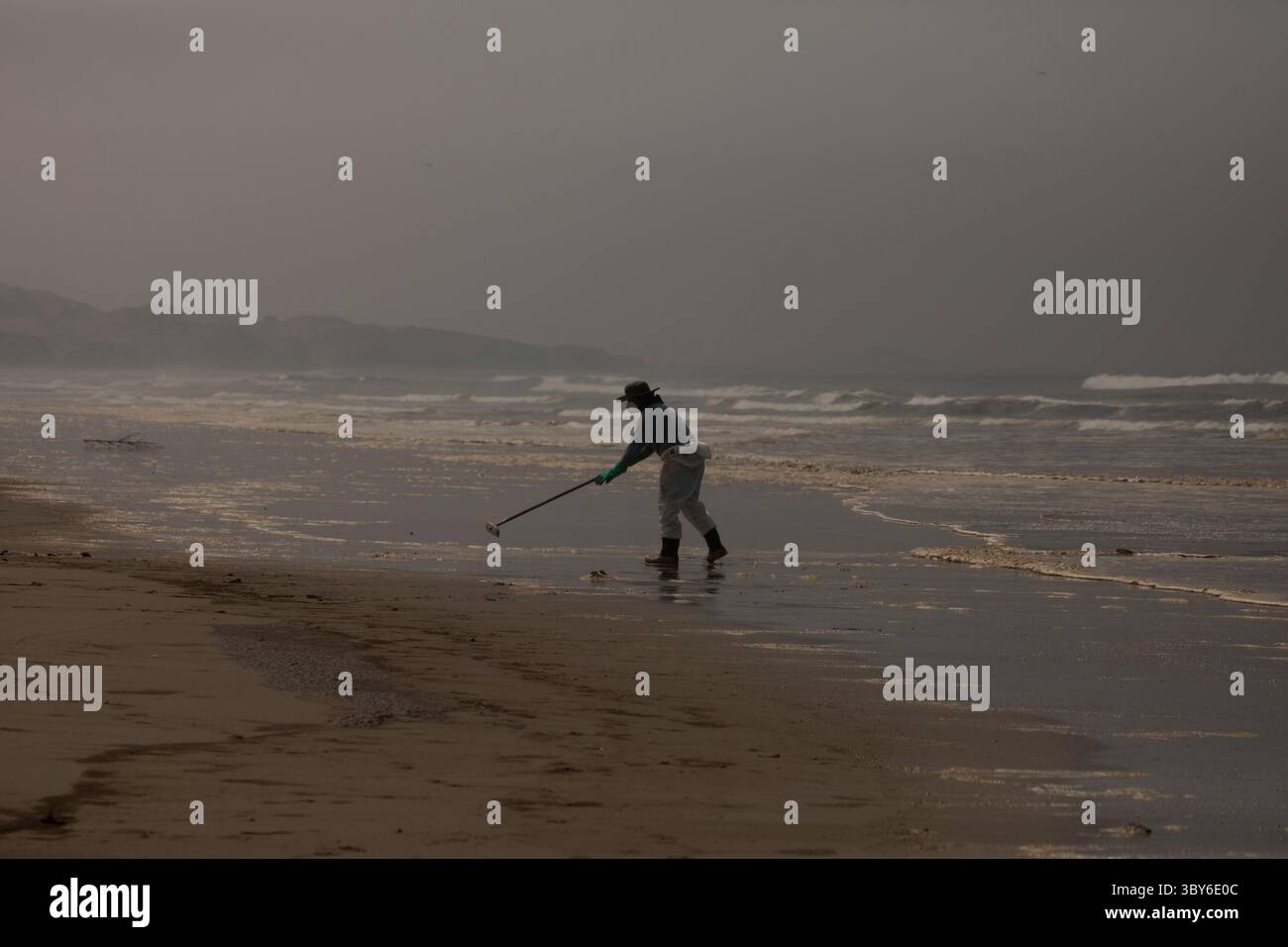 19 janvier 2022, Callao, Pérou : les travailleurs nettoient après un déversement de pétrole, sur la plage de Cavero dans le district de Ventanilla à Callao. Environ 6 000 barils (159 litres chacun) de pétrole se sont déversés lors du déchargement d'un pétrolier à la raffinerie de la Pampilla appartenant à la compagnie énergétique espagnole Repsol. (Crédit image : © Mariana Bazo/ZUMA Press Wire) Banque D'Images