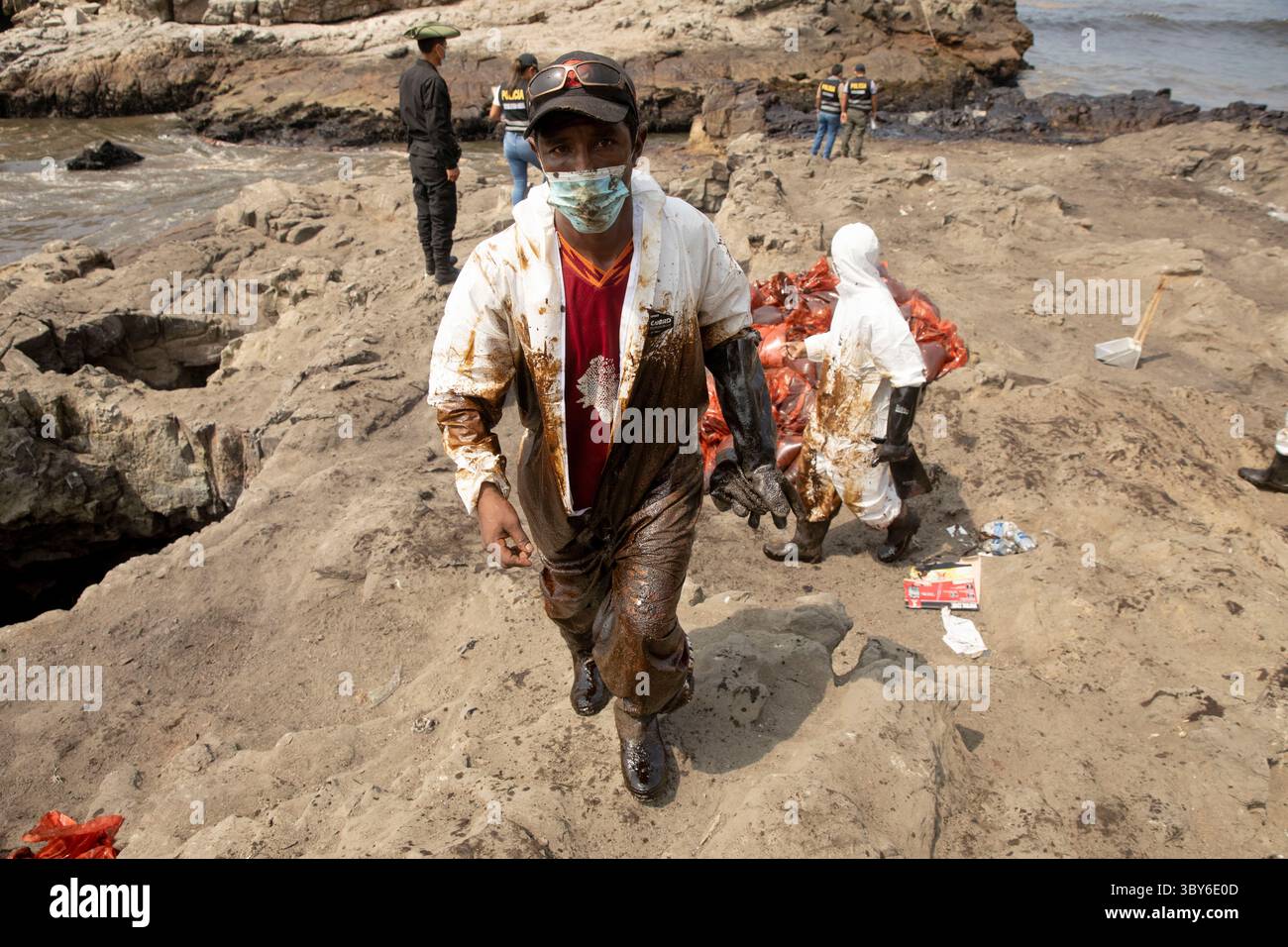 19 janvier 2022, Callao, Pérou : les travailleurs nettoient après un déversement de pétrole, sur la plage de Cavero dans le district de Ventanilla à Callao. Environ 6 000 barils (159 litres chacun) de pétrole se sont déversés lors du déchargement d'un pétrolier à la raffinerie de la Pampilla appartenant à la compagnie énergétique espagnole Repsol. (Crédit image : © Mariana Bazo/ZUMA Press Wire) Banque D'Images