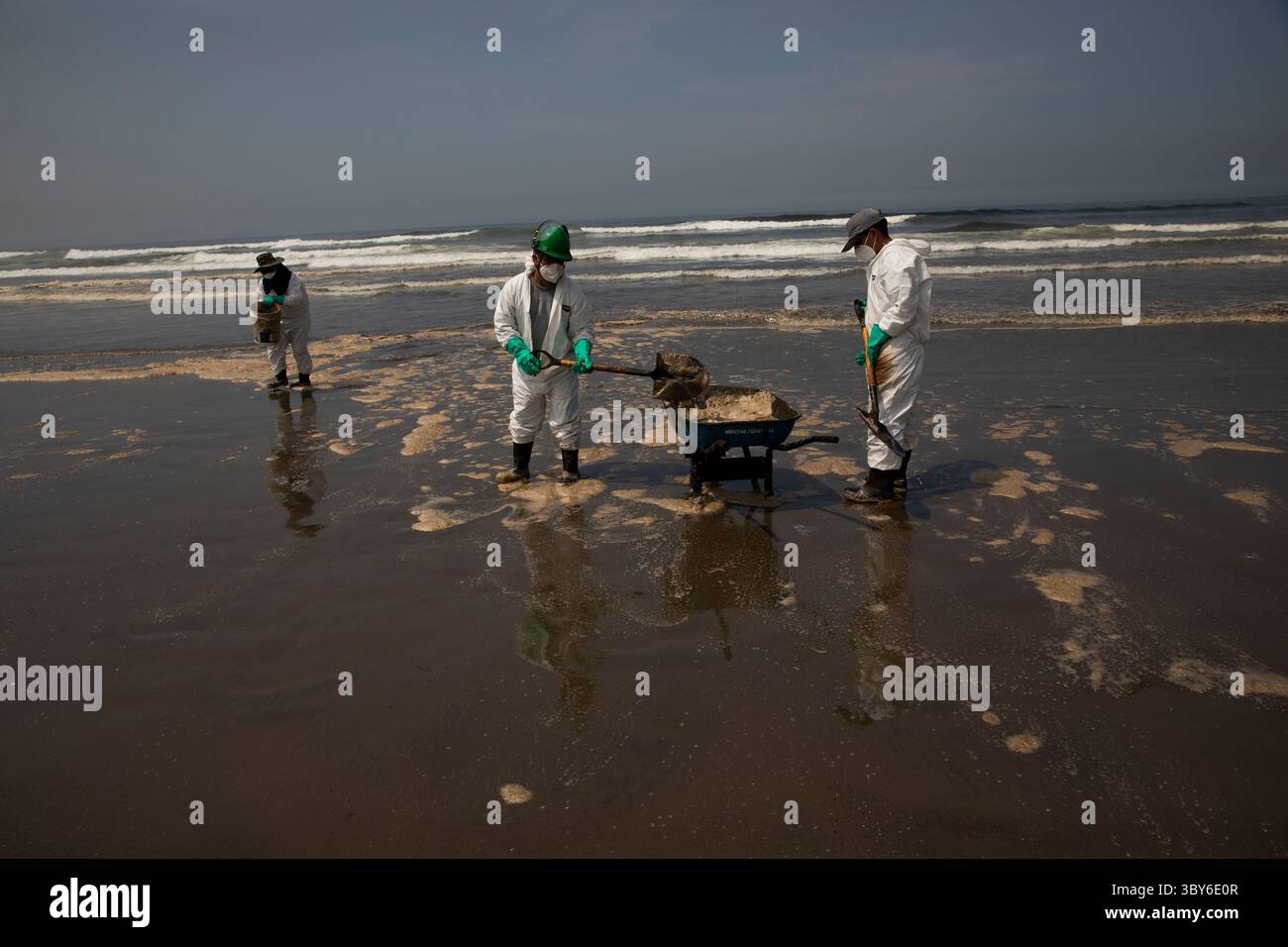19 janvier 2022, Callao, Pérou : les travailleurs nettoient après un déversement de pétrole, sur la plage de Cavero dans le district de Ventanilla à Callao. Environ 6 000 barils (159 litres chacun) de pétrole se sont déversés lors du déchargement d'un pétrolier à la raffinerie de la Pampilla appartenant à la compagnie énergétique espagnole Repsol. (Crédit image : © Mariana Bazo/ZUMA Press Wire) Banque D'Images