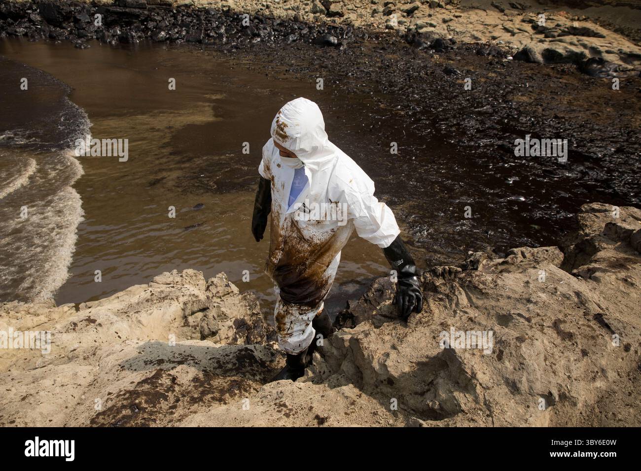 19 janvier 2022, Callao, Pérou : les travailleurs nettoient après un déversement de pétrole, sur la plage de Cavero dans le district de Ventanilla à Callao. Environ 6 000 barils (159 litres chacun) de pétrole se sont déversés lors du déchargement d'un pétrolier à la raffinerie de la Pampilla appartenant à la compagnie énergétique espagnole Repsol. (Crédit image : © Mariana Bazo/ZUMA Press Wire) Banque D'Images