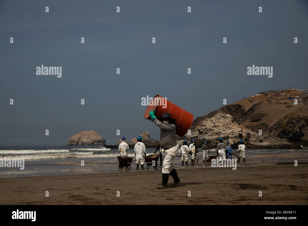 19 janvier 2022, Callao, Pérou : les travailleurs nettoient après un déversement de pétrole, sur la plage de Cavero dans le district de Ventanilla à Callao. Environ 6 000 barils (159 litres chacun) de pétrole se sont déversés lors du déchargement d'un pétrolier à la raffinerie de la Pampilla appartenant à la compagnie énergétique espagnole Repsol. (Crédit image : © Mariana Bazo/ZUMA Press Wire) Banque D'Images