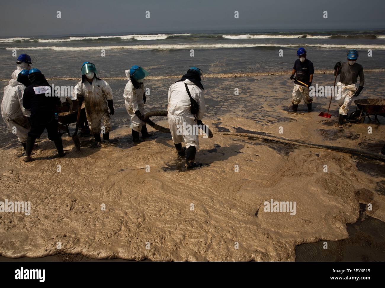19 janvier 2022, Callao, Pérou : les travailleurs nettoient après un déversement de pétrole, sur la plage de Cavero dans le district de Ventanilla à Callao. Environ 6 000 barils (159 litres chacun) de pétrole se sont déversés lors du déchargement d'un pétrolier à la raffinerie de la Pampilla appartenant à la compagnie énergétique espagnole Repsol. (Crédit image : © Mariana Bazo/ZUMA Press Wire) Banque D'Images
