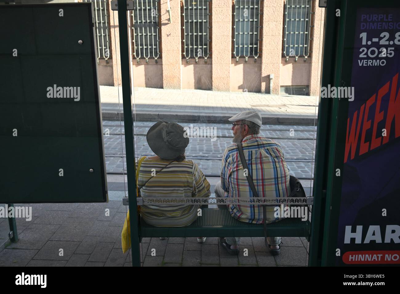 helsinki finlande couple de personnes âgées attendant à un arrêt de tram sur Aleksanterinkatu 00100 Helsinki, Finlande Banque D'Images