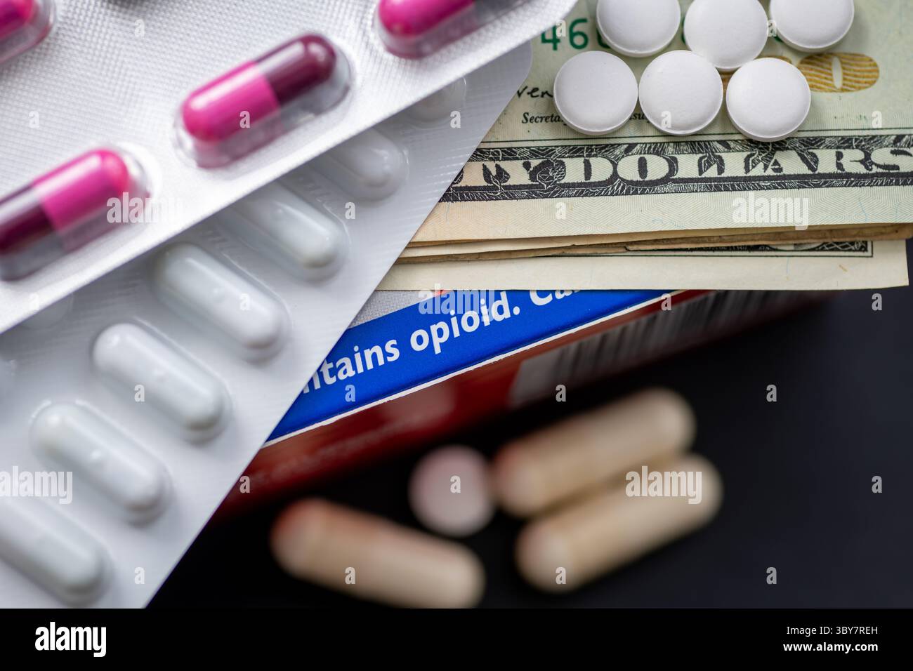 Un concept de toxicomanie aux opioïdes avec des pilules médicales et des billets en dollars américains sur une boîte de médicaments contenant des opioïdes. Banque D'Images