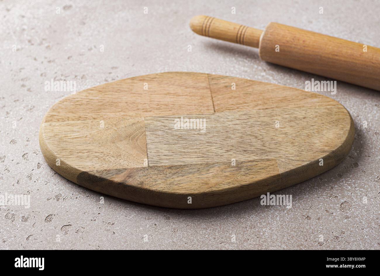 Nourriture, planche à découper vide en bois et un rouleau à pâtisserie en bois sur une table en pierre beige, maquette pour le design Banque D'Images