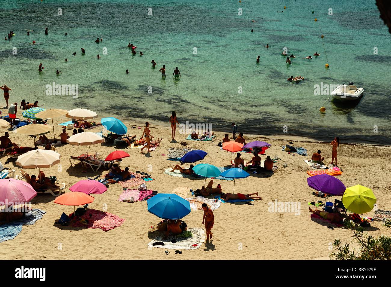 Vacanciers et amoureux de la plage profitant du soleil et de la mer à Portinatx à Ibiza dans la chaleur de midi de juillet. Banque D'Images