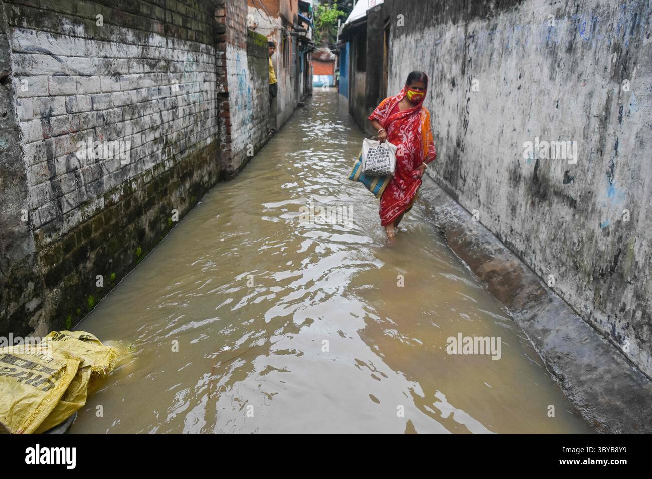 26 juin 2021, Kolkata, Bengale occidental, Inde : une dame fait son chemin à travers une ruelle inondée à Kolkata, Inde , le 26 juin 2021 . La marée haute sur le Gange a provoqué des inondations massives dans diverses parties des zones de basse altitude sur la rive du Gange à Kolkata (crédit image : © Debarchan Chatterjee/ZUMA Press Wire) Banque D'Images