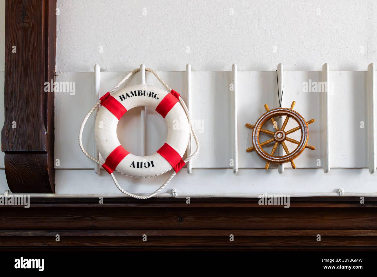 Hambourg, Allemagne - 1er juillet 2025:bouée Lifebuoy et roue de gouvernail, symboles de la mer. Intérieur de la Flussschifferkirche à Hambourg, église flottante sur un hi Banque D'Images