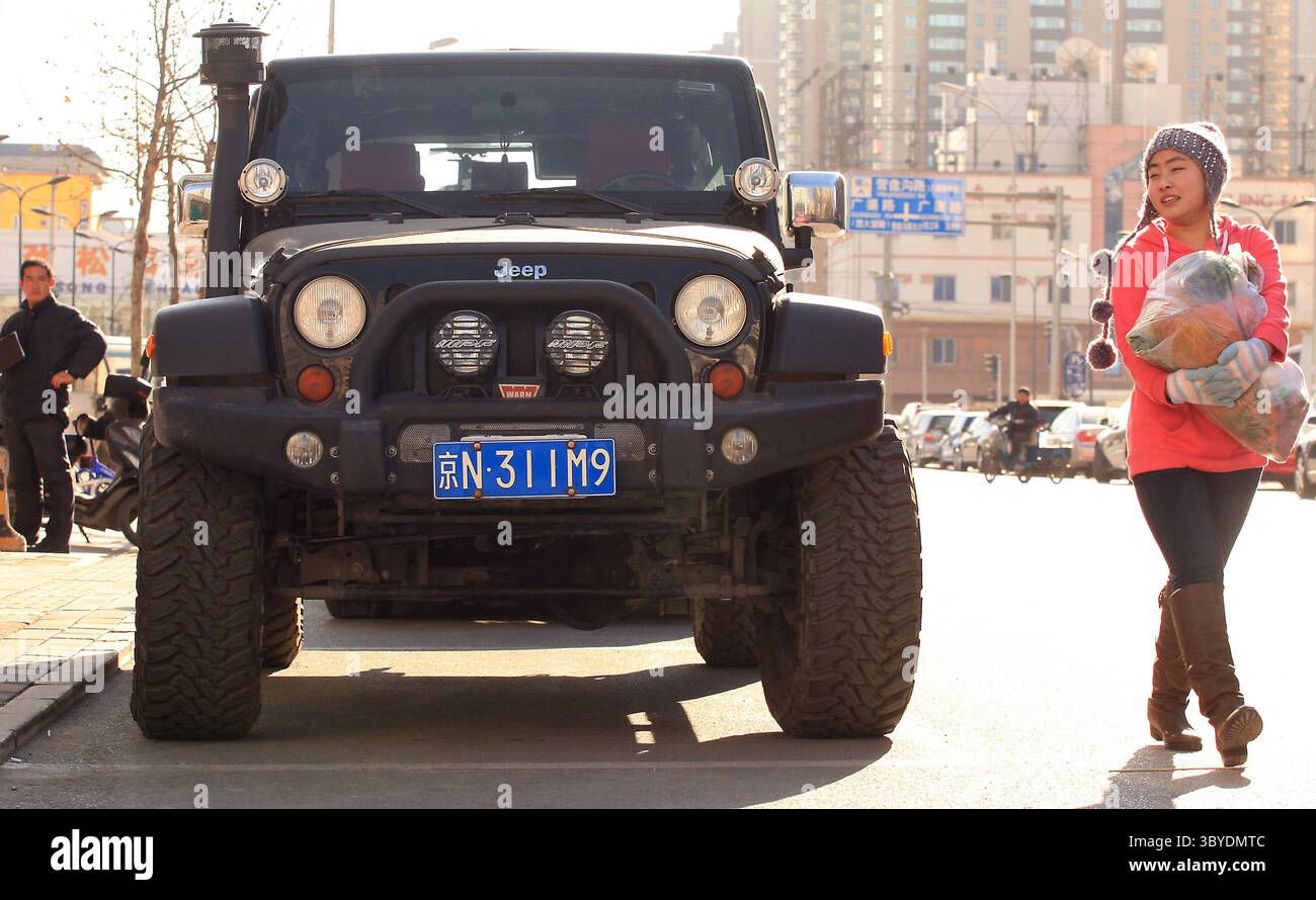 16 décembre 2011, PÉKIN, CHINE : des piétons chinois passent devant une jeep américaine garée sur le trottoir à Pékin le 16 décembre 2011. La Chine imposera des droits punitifs allant jusqu'à 22 pour cent sur les grandes voitures et les VUS exportés des États-Unis, a déclaré le ministère chinois du commerce plus tôt cette semaine, le dernier d'une série de différends commerciaux entre les deux plus grandes économies du monde. (Crédit image : © Stephen Shaver/ZUMA Press Wire) Banque D'Images