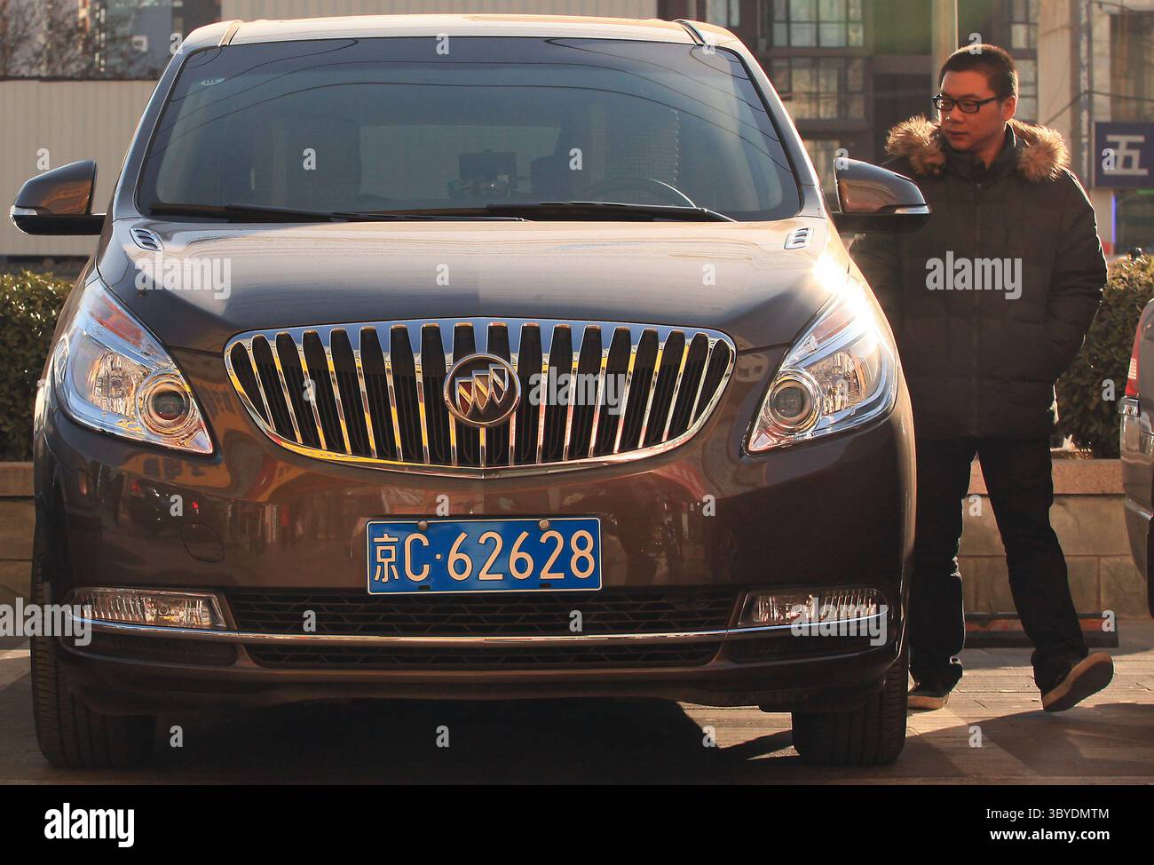 16 décembre 2011, PÉKIN, CHINE : un Chinois passe devant une mini-fourgonnette Buick américaine garée devant une banque chinoise à Pékin le 16 décembre 2011. La Chine imposera des droits punitifs allant jusqu'à 22 pour cent sur les grandes voitures et les VUS exportés des États-Unis, a déclaré le ministère chinois du commerce plus tôt cette semaine, le dernier d'une série de différends commerciaux entre les deux plus grandes économies du monde. (Crédit image : © Stephen Shaver/ZUMA Press Wire) Banque D'Images