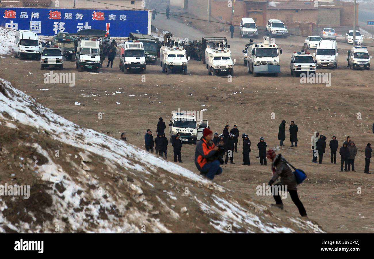 4 février 2012, XIAHE, PROVINCE DU GANSU, CHINE : des véhicules militaires et policiers chinois pour le conflit urbain (arrière-plan) sont déployés dans l'espoir de prévenir ou d'arrêter les affrontements potentiels entre Tibétains et Chinois au monastère de Labrang, le plus grand monastère tibétain en dehors de Lhassa, lors du festival du monlam tibétain à Xiahe, une petite ville de la province du Gansu sur le plateau tibétain, le 4 février 2012. Des milliers de moines tibétains, pèlerins et nomades ont convergé vers le monastère pour le rituel annuel ''ensoleillement du Bouddha'', dans lequel se trouve le plus grand Thangka du Bouddha (tapisserie brodée) du monde Banque D'Images