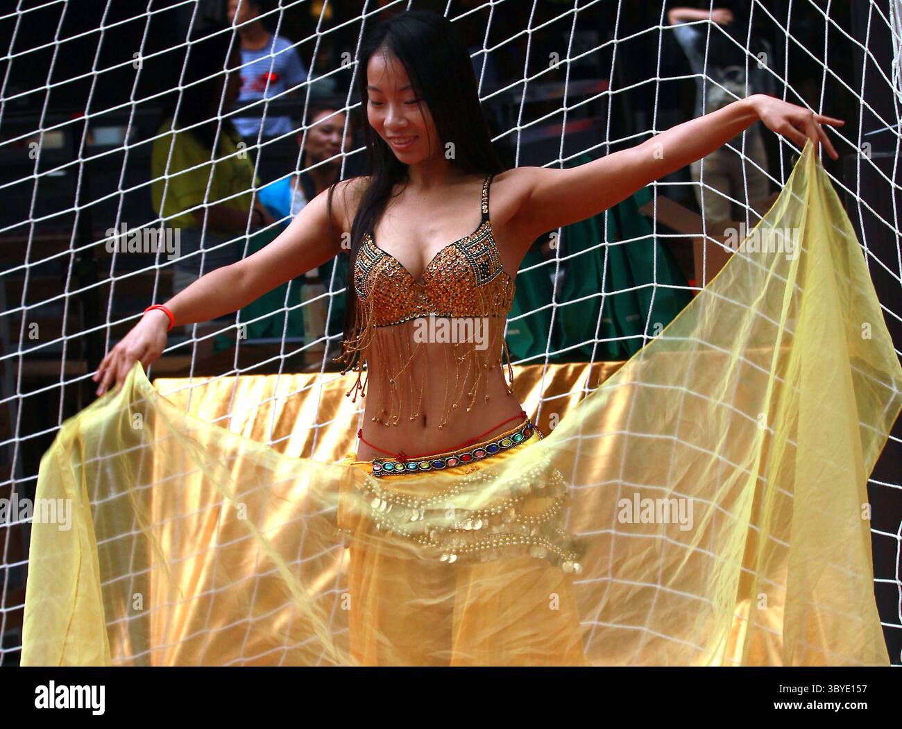 25 juin 2014, PÉKIN, CHINE : une femme chinoise danse le ventre devant un filet de football lors de la fête de la Coupe du monde de trottoir dans le centre-ville de Pékin le 25 juin 2014. La fièvre de la Coupe du monde a balayé la capitale chinoise bien que le pays ne se qualifie pas pour le tournoi. (Crédit image : © Stephen Shaver/ZUMA Press Wire) Banque D'Images