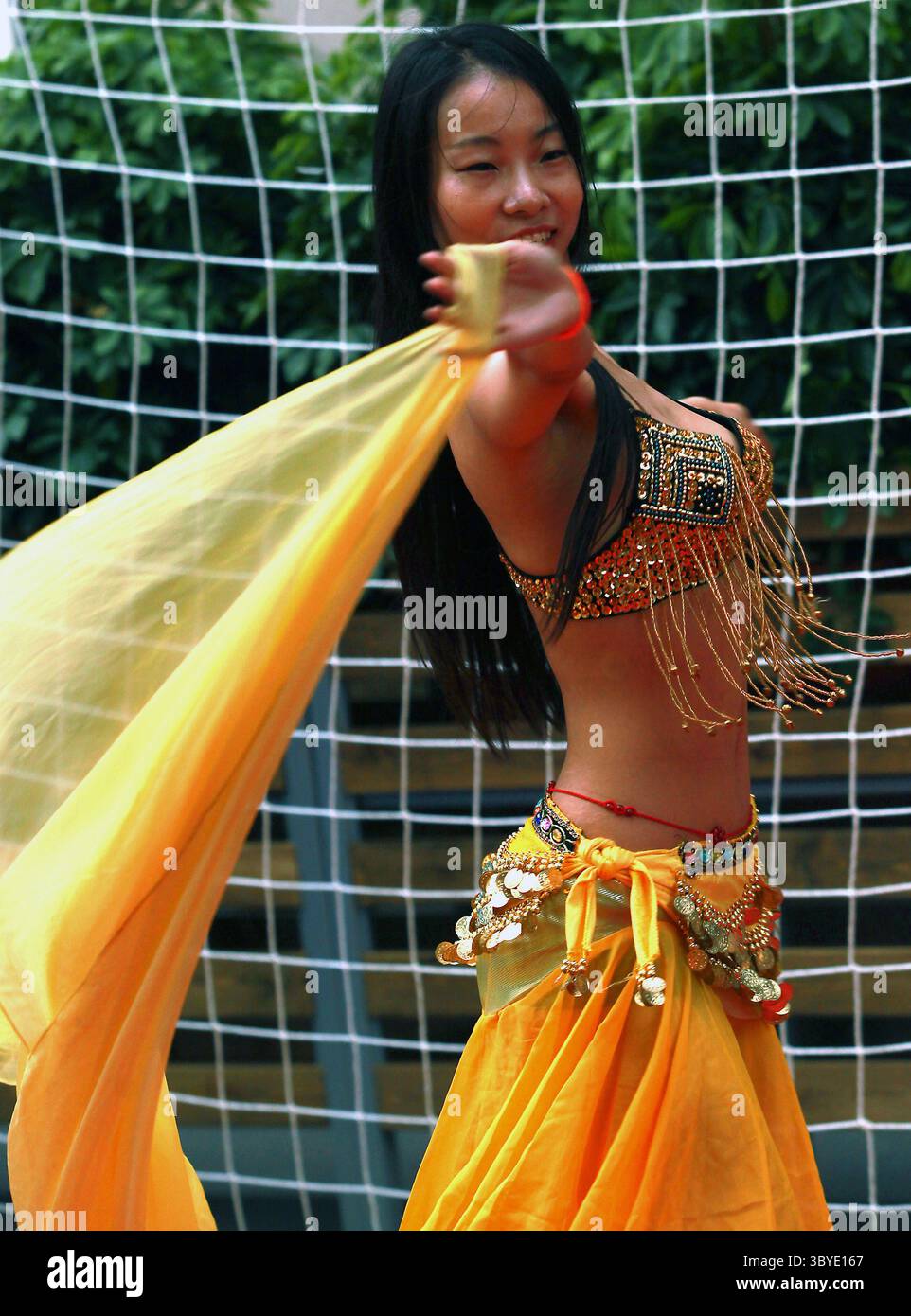 25 juin 2014, PÉKIN, CHINE : une femme chinoise danse le ventre devant un filet de football lors de la fête de la Coupe du monde de trottoir dans le centre-ville de Pékin le 25 juin 2014. La fièvre de la Coupe du monde a balayé la capitale chinoise bien que le pays ne se qualifie pas pour le tournoi. (Crédit image : © Stephen Shaver/ZUMA Press Wire) Banque D'Images