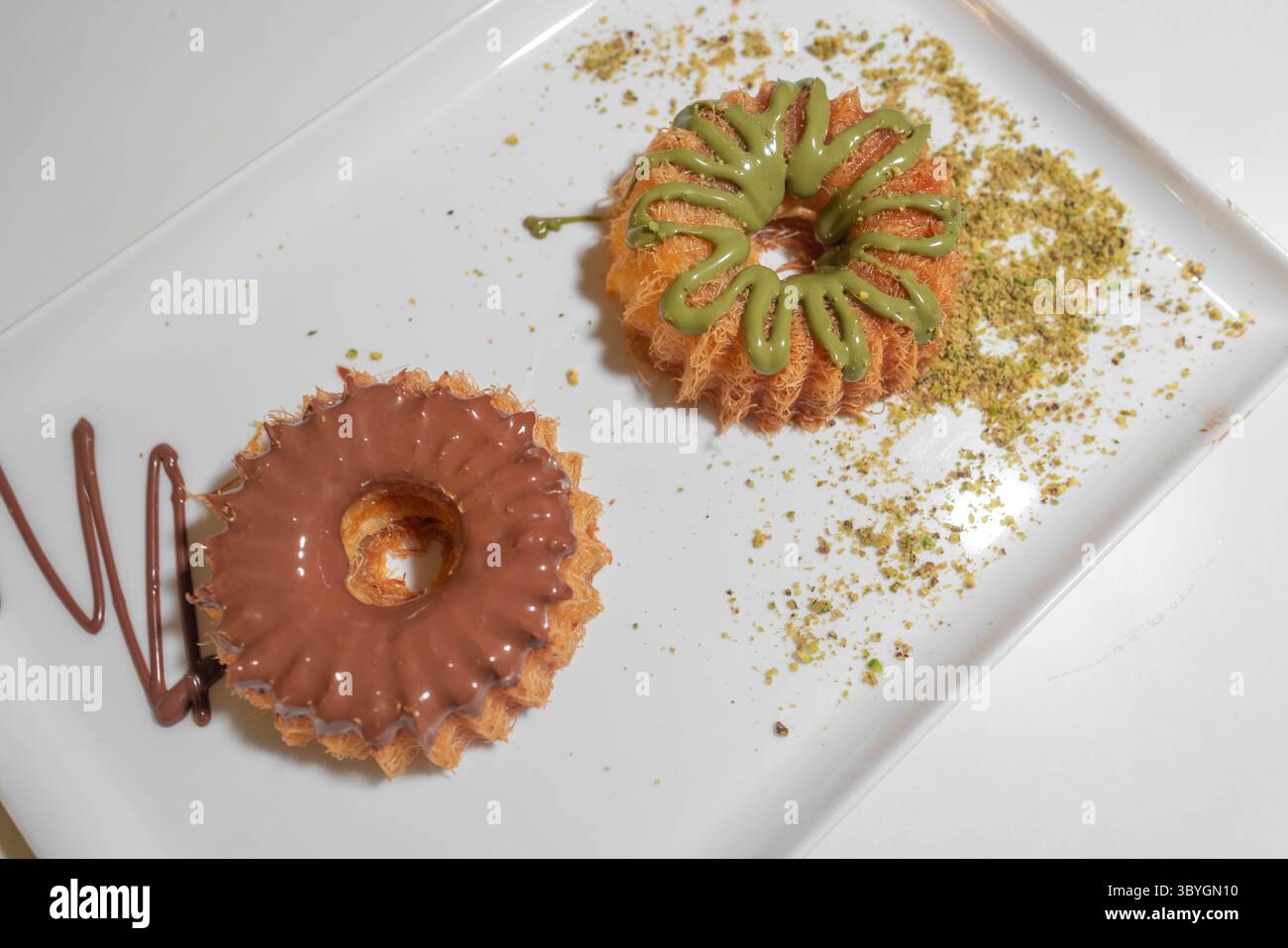 Délicieux bonbons faits de gâteaux à la crème avec une variété de saveurs - crème au chocolat et dessert rond aux noix - dessert du moyen-Orient avec une touche moderne Banque D'Images