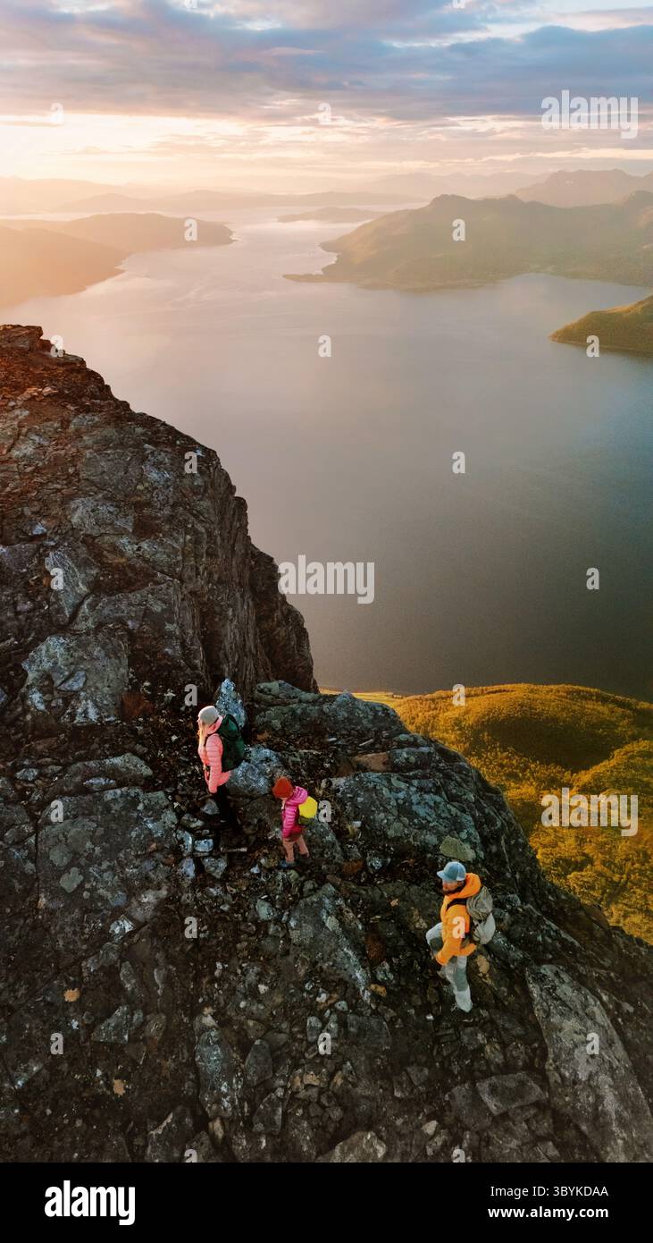 Voyage de randonnée en Norvège - parents de famille actifs avec des enfants grimpant des montagnes style de vie sain vacances visite en groupe en plein air, vue aérienne coucher du soleil fjord l Banque D'Images