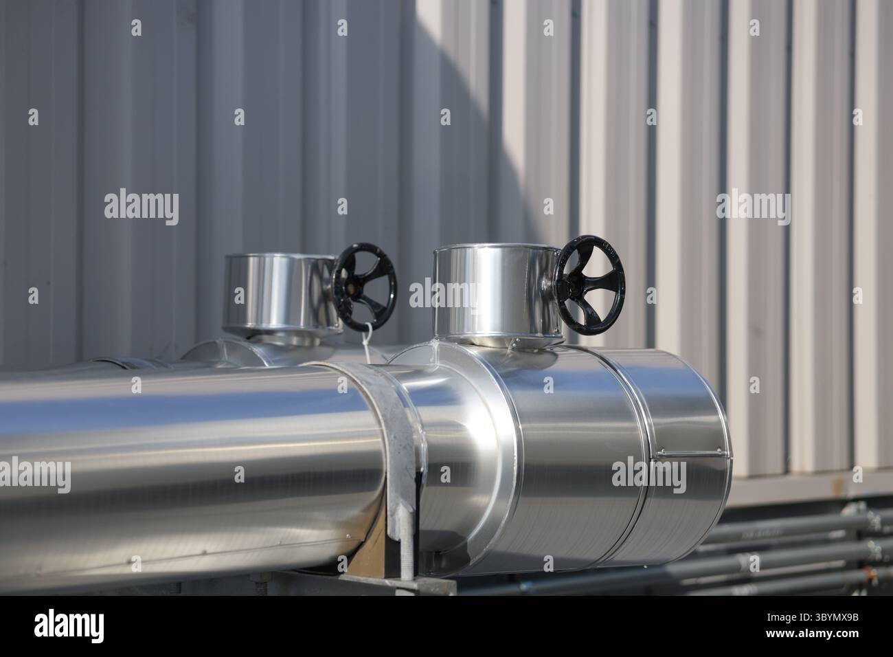 Point de travail en aluminium de gaine de tuyau où la valve actionnée par volant dépasse. Travaux d'isolation pour tuyaux d'eau froide pour éviter la condensation. Banque D'Images